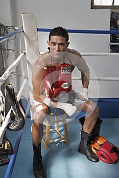 Man sitting in corner of boxing ring