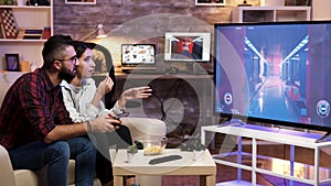 Man sitting on couch playing video games on television