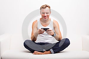 Man sitting on couch and using his smartphone