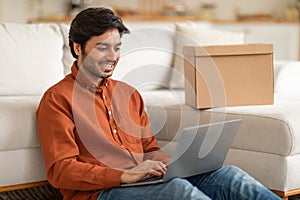 Man Sitting on a Couch Using a Laptop