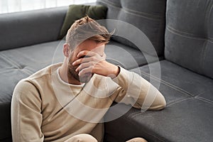 Man sitting and covering his face