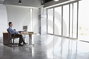 Man Sitting At Desk In Empty Office