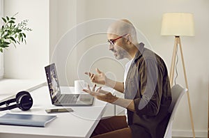 Man sitting at desk in home office and having online business meeting on laptop computer