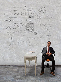 Man sitting on desk and physic formula on wall