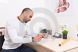 Man sitting at a desk writing notes in an office