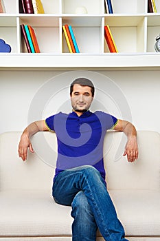 Man sitting on divan and smiling