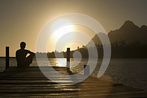 Man Sitting On Dock By Lake