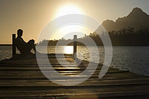 Man Sitting On Dock By Lake photo