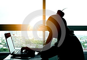 A man sitting down, his face unsettled. At the computer desk He has headaches and stress. Cause of hard work and insufficient rest