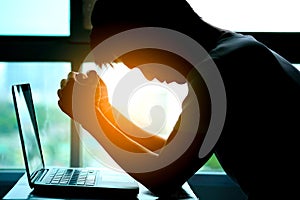 A man sitting down, his face unsettled. At the computer desk He has headaches and stress. Cause of hard work and insufficient rest