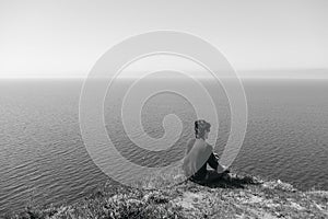 Man sitting on edge of cliff at edge