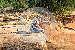 Man sitting on the edge of a cliff, Palo Duro Canyon