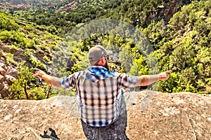 Man sitting on the edge of a cliff, Palo Duro Canyon