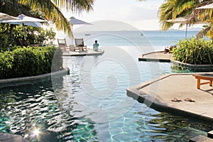 Man sitting at the edge of infinity pool