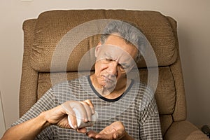 Man sitting in an EZ chair taking his medication