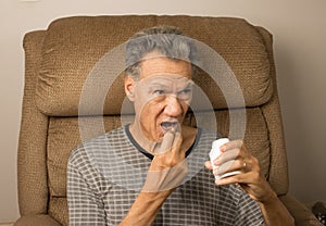 Man sitting in an EZ chair taking his medication