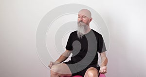 Man sitting on fitness ball doing neck spine exercise