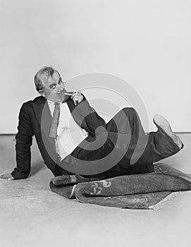 Man sitting on floor lighting cigarette