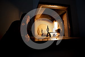 Man sitting in front of a burning fire on a hearth