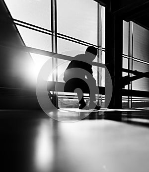 Man sitting in front of a windowed building