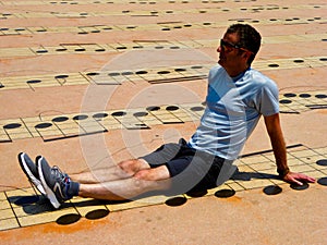 A man sitting on the ground with Musical note pattern background