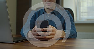 Man sitting at his desk home on desktop computer. Starts using smartphone, uses social media app, emailing business