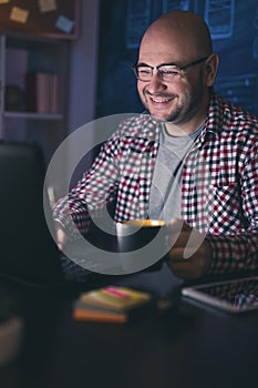Man drinking coffee while working late