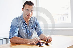 Man sitting in his office and using digital tablet