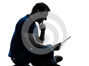 Man sitting holding watching digital tablet silhouette