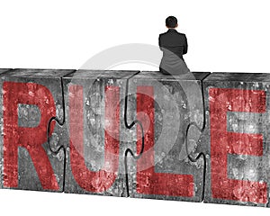 Man sitting on huge concrete puzzles with red rule word