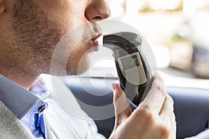 Man Sitting Inside Car Taking Alcohol Test