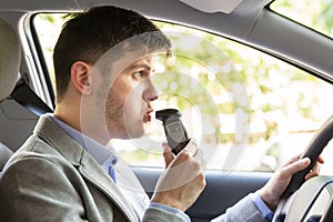 Man Sitting Inside Car Taking Alcohol Test