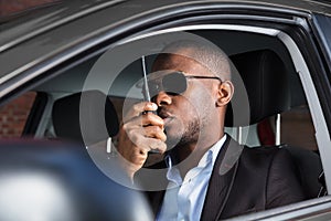 Man Sitting Inside Car Talking On Walkie Talkie