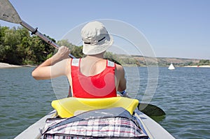 Man sitting in kayak and paddling, active summer vacation on river