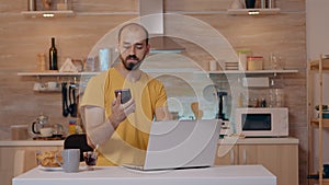 Man sitting in kitchen switch off the lights using voice command