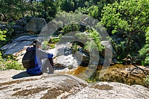 Man sitting on a large rock and enjoying the mountain landscape, Guadarrama Madrid.