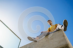 Man sitting on a ledge looking around