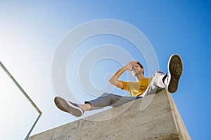 Man sitting on a ledge looking around