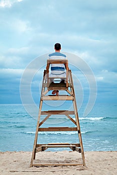 Man sitting on lifeguard chair