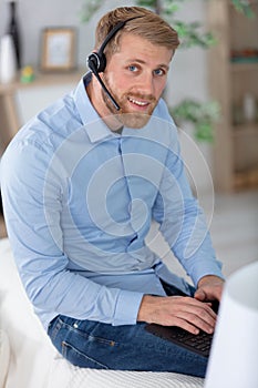 man sitting in living room at home wearing headset