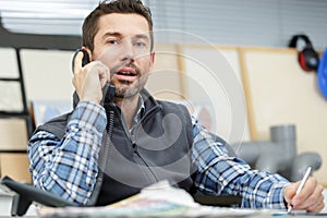 man sitting in office on phone