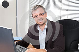man sitting in office working on computer