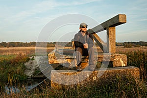 A man sitting on an old bridge