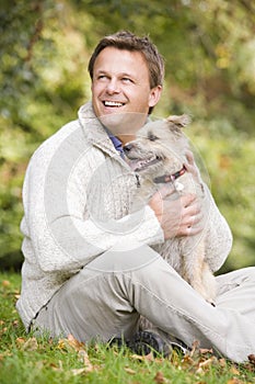 Man sitting outside holding dog
