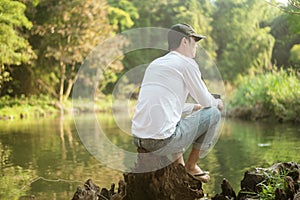 Man is sitting over lake   enjoying with nature and coffee   travel relaxation concept