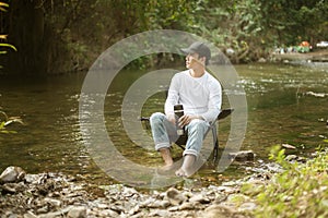 Man is sitting over lake   enjoying with nature and coffee   travel relaxation concept