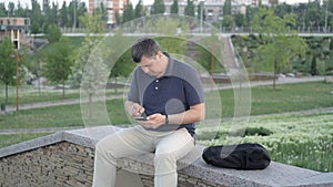 A man sitting in the Park on a green background, an unknown steals his bag and runs away