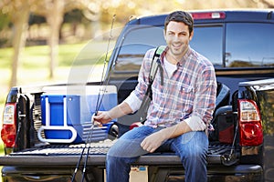 Man Sitting In Pick Up Truck On Camping Holiday