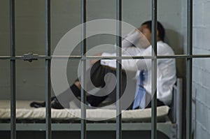 Man Sitting In Prison Cell