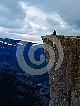 Man sitting on Pulpit Rock Preikestolen Norway